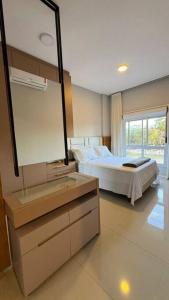 - une chambre avec un lit, un lavabo et un miroir dans l'établissement Lindo apartamento frente mar em condomínio club, à Florianópolis