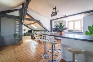een keuken en een woonkamer met een bar met krukken bij Le nid Perché # reims in Reims