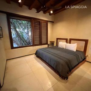 um quarto com uma cama e uma grande janela em Zihuatanejo Lovely Villa em Zihuatanejo