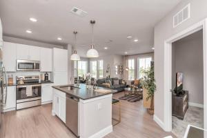 a kitchen and living room with white cabinets at The Golden Treasure near Kemah Boardwalk! in Kemah