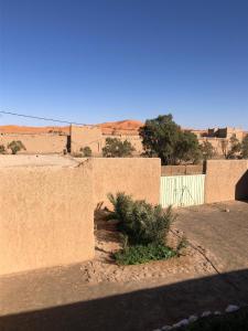 uma vista para um deserto com um edifício e uma parede em DAR AMMAR em Merzouga