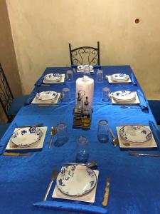 uma mesa azul com pratos e uma vela em DAR AMMAR em Merzouga