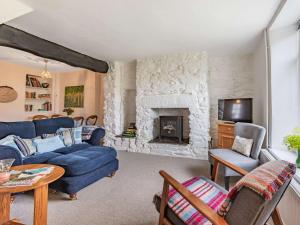 - un salon avec un canapé bleu et une cheminée dans l'établissement 2 Bed in Tavistock 83623, à Tavistock