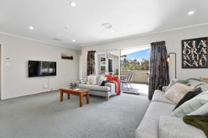 uma sala de estar com um sofá e uma mesa em Stay at 5A em Rotorua