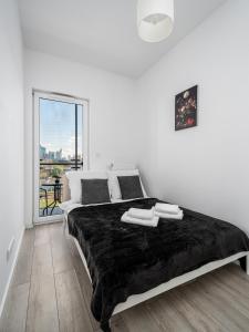 a white bedroom with a large bed and a window at Apart D&K Free Parking Aleja Prymasa Tysiąclecia 83A in Warsaw
