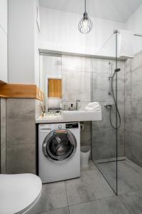 a bathroom with a washing machine and a sink at Apart D&K Free Parking Aleja Prymasa Tysiąclecia 83A in Warsaw