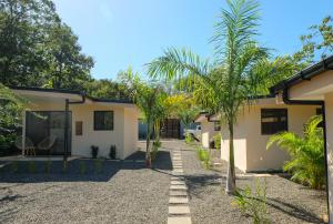 ein Haus mit Palmen davor in der Unterkunft MY - Cosy Lodges in Paraíso