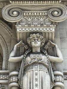 Una statua di una donna sul lato di un edificio di Hotel Genova Liberty a Genova