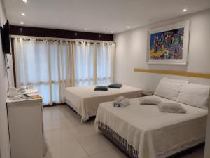 a hotel room with two beds and a window at Pousada Beira Mar - Suítes Frente ao mar in Torres