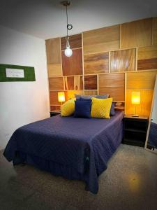 a bedroom with a bed with blue and yellow pillows at Casa a 8min del aeropuerto. Z11 in Guatemala