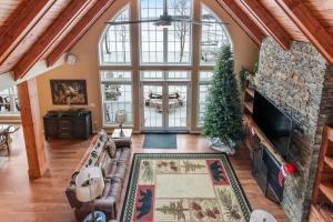una sala de estar con una gran chimenea de piedra y un sofá. en North Twin Lake House, en Phelps