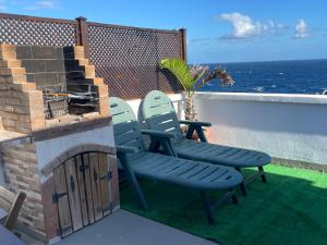 two chairs sitting next to a fireplace on a balcony at Penthouse Maines View in Pájara