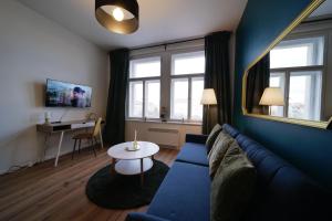 a living room with a blue couch and a table at Majestic Square View Residence in Prague