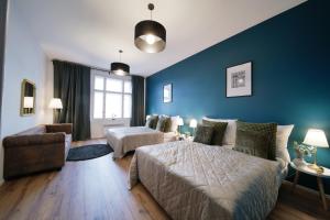 1 dormitorio con paredes azules, 1 cama y 1 sofá en Majestic Square View Residence, en Praga