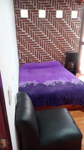 um quarto com uma cama e uma cadeira de couro em Rancho los Alebrijes Zacatlan em Zacatlán