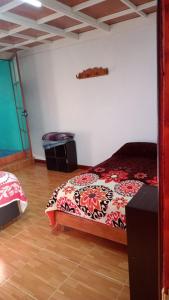 um quarto com uma cama com um cobertor vermelho e branco em Rancho los Alebrijes Zacatlan em Zacatlán
