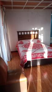 um quarto com uma cama com um cobertor vermelho em Rancho los Alebrijes Zacatlan em Zacatlán
