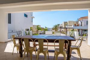 a wooden table and chairs on a balcony at Villa Bliss by Lumina in Cabo San Lucas