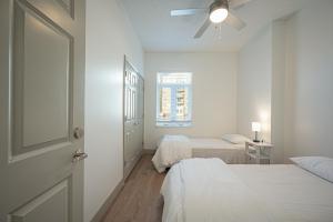 a white bedroom with two beds and a window at Classy Uptown Darling in Charlotte