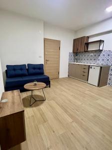 sala de estar con sofá azul y cocina en The ONE Suites- with terrace in City Center en Kumanovo
