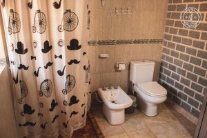 a bathroom with a toilet and a shower curtain with bats at El Progreso Molinos in Molinos