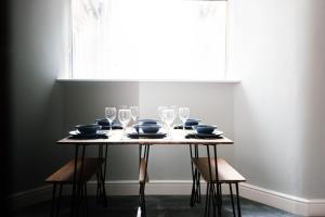 a table with wine glasses and plates on it at 4 Bedroom House - Great for Group Stays in Crewe