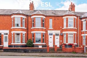 una casa in mattoni rossi con porte e finestre bianche di 4 Bedroom House - Great for Group Stays a Crewe