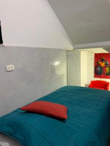 a bedroom with a blue bed with a red pillow at Hamuy's Lodge in Ica
