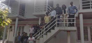 a group of people standing on the stairs of a building at Vacanza Estate House in Kakkabe