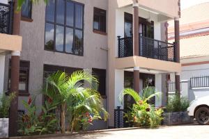 a building with palm trees in front of it at Orchid Suites, Kira in Bulindo