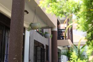 a building with potted plants on the side of it at Orchid Suites, Kira in Bulindo