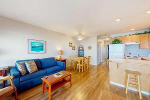 a living room with a blue couch and a kitchen at Nye Beach Condo in Newport
