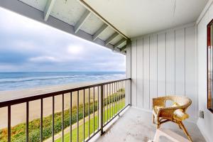 a balcony with a chair and a view of the ocean at Nye Beach Condo in Newport