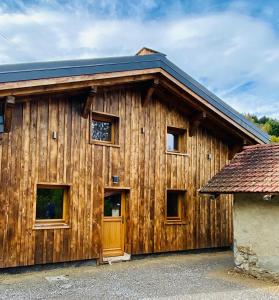 un edificio de madera con ventanas y techo azul en Chalet du Bonheur en Saint-Gervais-les-Bains