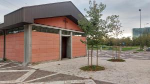 ein rotes Gebäude mit einem Baum auf einem Parkplatz in der Unterkunft 15 minuti di metro dal Duomo " TheRussianFlower" in Mailand