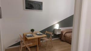 a room with a table and chairs and a bed at 15 minuti di metro dal Duomo " TheRussianFlower" in Milan