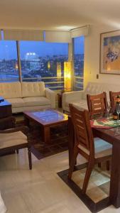 uma sala de estar com um sofá, uma mesa e cadeiras em Precioso depto vista al mar Concon Condominio Tipo Resort 2 dormitorios em Concón