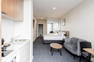 Habitación de hotel con cama y sofá en Durham Serviced Apartments en Adelaida