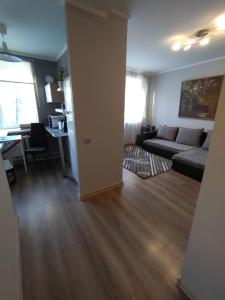 ein Wohnzimmer mit einem Sofa und einem Tisch in der Unterkunft Saknes apartamenti in Riga