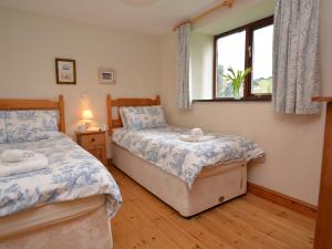 a bedroom with two beds and a window at 2 Bed in Bude CORYB in Morwenstow