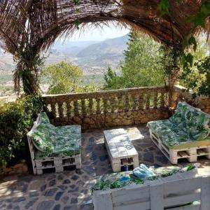 um pátio com 2 cadeiras e uma mesa em Casa Cueva "El Mirador de Piedra" em Pegalajar
