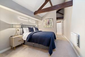 um quarto com uma cama grande e um cobertor azul em NEW Large luxurious 2 bed city penthouse + parking em Leicester