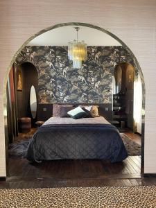 - une chambre avec un grand lit et un grand miroir dans l'établissement Studio indépendant comme une suite d’hôtel, à Villers-Cotterêts