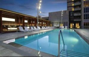 una grande piscina con sedie bianche in un edificio di Luxury 2 Bedroom Downtown a Toronto