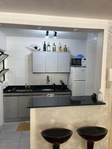 uma cozinha com dois bancos pretos no meio em Apartamento Bem Localizado no Centro de Porto Alegre em Porto Alegre