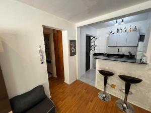 uma cozinha com um balcão e dois bancos num quarto em Apartamento Bem Localizado no Centro de Porto Alegre em Porto Alegre