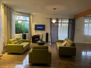 a living room with two couches and a tv at Heaven Corner with Mountain Sunset and Seaview 