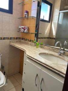 a bathroom with a sink and a mirror at Flat completo no centro. in Palmas +18 photos