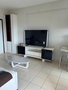 a living room with a large flat screen tv at Flat completo no centro. in Palmas