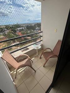 two chairs sitting on a balcony with a view at Flat completo no centro. in Palmas
